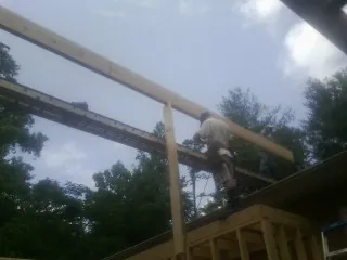 Carpenter setting a ridge beam over a new addition frame — Ice Dam Removal by Roofing Brothers in Erlanger