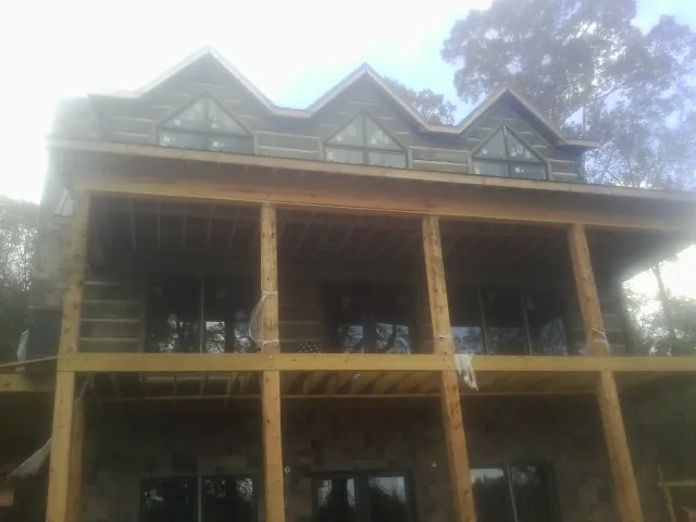 Dormers and porch framing on a large log home under construction — Roof Coating work by our crew in Erlanger